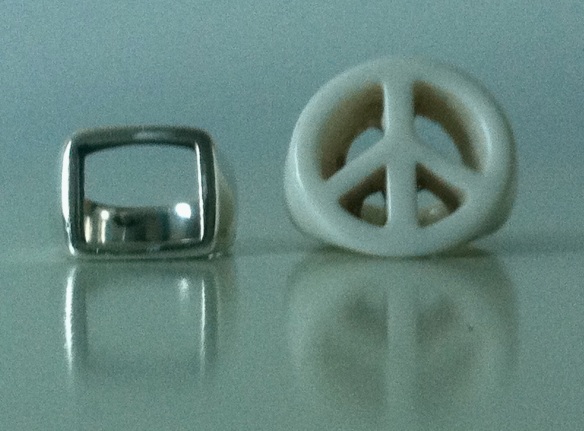 Silver Freedom ring and white plastic peace sign ring